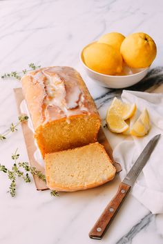 a loaf of lemon pound cake sitting on top of a counter next to sliced lemons