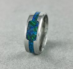 -Mineral(s): Malachite, Blue Achat -Opal(s): Blue Opal -Ring Material: Stainless Steel 316L -Ring Width: 6mm, 8mm -Shipping: EU:6-10 Workdays, Outside The EU: 7- 14 Workdays -Ring Inside: Comfort Fit Introducing our exquisite Handmade Stainless Steel Ring with a captivating inlay filled with crushed blue achat, malachite minerals, and blue opal. This meticulously crafted piece of jewelry is a true testament to the beauty of nature's wonders and the artistry of our skilled artisans. The central feature of this ring is the inlay, carefully filled with crushed blue achat, malachite minerals, and blue opal. Let's delve into the enchanting meanings behind these precious minerals, each adding a touch of mystique to this stunning piece: Blue Achat: Known for its calming and soothing properties, b Affordable Blue Hypoallergenic Rings, Engagement Ring Opal, Malachite Ring, Blue Opal Ring, Malachite Rings, Ring Opal, Protection Stones, Ring Blue, Ring Black