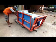 a man in an orange shirt is working on a blue and white box with red trim