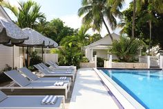 an empty pool with lounge chairs and umbrellas next to the swimming pool in front of it