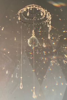 a chandelier hanging from the ceiling in front of a wall with light shining on it