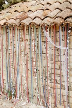 an old brick wall with ribbons attached to it