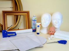 some crafting supplies are sitting on a table next to two mannequin heads