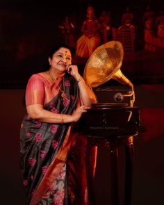 a woman standing next to an old record player