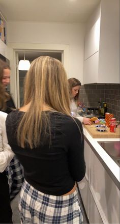 two women standing in a kitchen preparing food