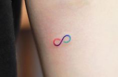 a small tattoo on the leg of a woman's arm with an infinite symbol