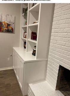 a white book shelf sitting next to a fireplace