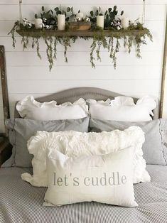 a bed with white pillows and some plants