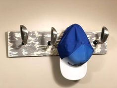 a baseball cap and hat hanging on a coat rack with two hats attached to it