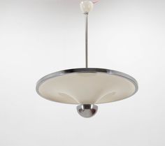 a light fixture hanging from the ceiling in a room with white walls and flooring