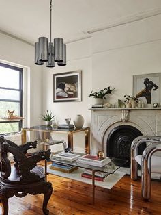 a living room filled with furniture and a fire place in front of a large window