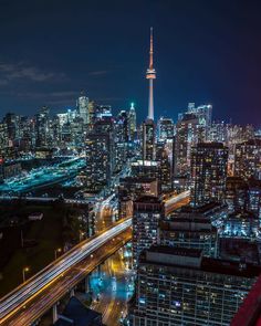 the cityscape is lit up at night, with lights streaking down on it