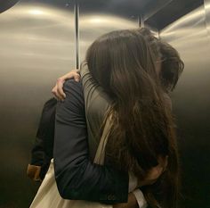 two people hugging each other in an elevator