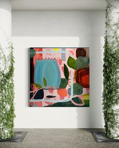 an abstract painting hangs on the wall next to potted plants