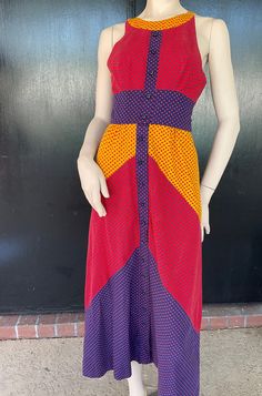 1970s Craig sundress. Red, yellow and blue cotton. Shoulder straps attach to inside back and have two adjustments. 16 button front.  Five buttons on bodice are decorative. Buttons on skirt are functional. Nylon zip back. Measurements  32" bust 22" waist 38" hips 16" bodice length 50" length Cute dress shows well with no obvious wear or damage. Retro Multicolor Dresses For Daywear, Vintage Multicolor Sundress For Summer, Retro Multicolor Sundress For Summer, Retro Multicolor Sleeveless Sundress, 1970s Style Red Summer Dresses, 1970s Red Summer Dresses, Red 1970s Style Summer Dress, Vintage Multicolor Buttoned Dresses, Vintage Multicolor Dresses With Buttons