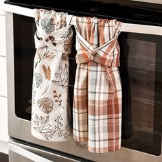 two kitchen towels hanging on the oven door handle and in front of it is an oven