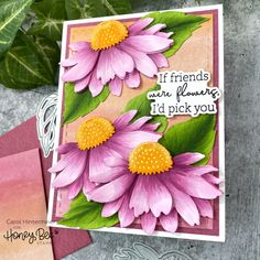 a close up of a card with flowers on it and a plant in the background