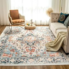 a living room with a couch, chair and rug on the floor in front of a window