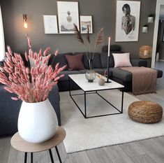 a living room filled with furniture and a white rug on top of a hard wood floor