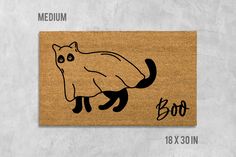 a door mat with an image of a cat on it and the words boo written in black