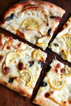 sliced pizza with lemons and olives on a cutting board