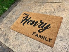 a door mat that says the henry family on it in front of a sidewalk with grass