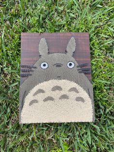 a rug with a totoro on it laying in the grass