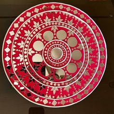 a red and white plate sitting on top of a table next to a black counter