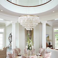 a dining room table with chairs and a chandelier in the middle of it