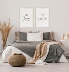 two framed pictures on the wall above a bed in a bedroom with pillows and blankets