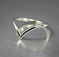 Dainty .925 sterling silver V curve wishbone ring. Minimalist chevron design for everyday wear. Handmade in 14 gauge wire.  Available in shiny finish. SIZES: 3-16 MORE SILVER RINGS: https://www.etsy.com/ca/shop/JenniferWoodJewelry?ref=seller-platform-mcnav&section_id=37080248  Established Etsy Seller since 2006. Get 15% off when you join my email list to receive monthly updates about new work and subscriber-only deals. No spam. Just a lot of shiny new things. Subscribe at: http://eepurl.com/iqWq Morganite Engagement Ring Set, Pink Morganite Engagement Ring, Wishbone Ring, Arrow Ring, Silver Ring Designs, Chevron Ring, Morganite Engagement Ring, Wire Rings, Midi Rings