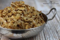 a metal bowl filled with food on top of a wooden table