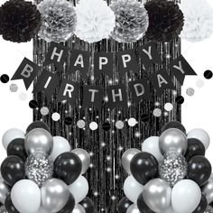 a black and white birthday party with balloons, pom poms and streamers