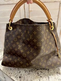 Introducing the beautiful and stylish Louis Vuitton Artsy Shoulder Bag MM in brown monogram canvas. This large-sized shoulder bag features a spacious interior lined with soft microfiber, gold-tone hardware, and a comfortable leather strap with a 2.7-inch drop. This bag is perfect for any occasion, whether it's a casual outing or a night out on the town. The open/no closure design provides easy access to your belongings, and the versatile beige handle/strap color complements any outfit. Add the Louis Vuitton Artsy Shoulder Bag MM to your collection today! This bag is in fantastic condition on the outside there are no cracks on the top or any on the corners. The only 2 flaws is the strap has a few marks on it and the inside has a few stains. All of this is in the photos. Any questions feel f Louis Vuitton Handbags Outlet Cheap, Vintage Louis Vuitton Handbags, Louis Vuitton Handbags Outlet, Louis Vuitton Artsy Mm, Mm Monogram, Louis Vuitton Artsy, Closure Design, Louis Vuitton Purse, Lv Handbags