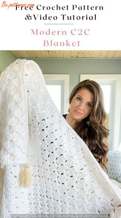 a woman is holding up a white crochet afghan