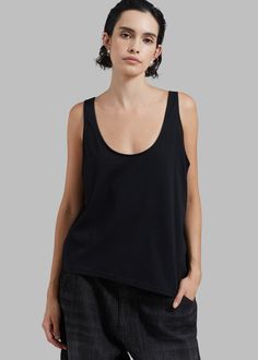 Color: Black Lightweight cotton fabric Reversible style Relaxed fit Round neckline Asymmetrical hem Sleeveless Unlined 100% Cotton Machine Wash Cold By The Frankie Shop. Imported Cotton Tops With Wide Straps For Everyday, Versatile Cotton Tank Top With Scoop Neck, Chic Black Cotton Tank Top, Black Cotton Tank Top For Layering, Chic Cotton Scoop Neck Tank Top, Versatile Cotton Scoop Neck Tank Top, Chic Black Relaxed Fit Tank Top, Black Compressive Tank Top Athleisure, Black Relaxed Fit Tank Top