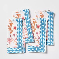 four napkins with blue and orange designs on them