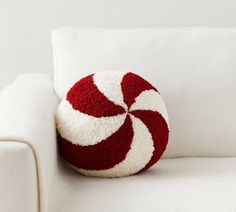 a red and white pillow sitting on top of a white couch