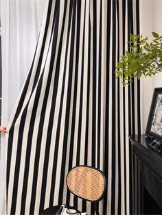 a black and white striped curtain in a living room with a chair next to it