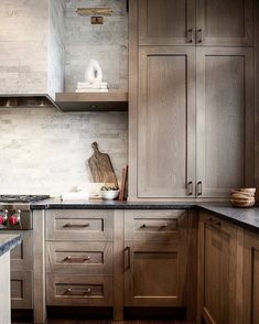 a kitchen with wooden cabinets and marble counter tops, along with dark wood flooring