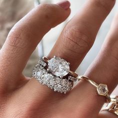 a woman's hand with two rings on it and one ring has three diamonds