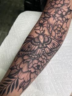 a woman's arm with flowers and a butterfly on it