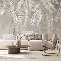 a living room with white furniture and palm leaves on the wall behind it is a coffee table