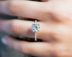 a woman's hand with a diamond ring on it