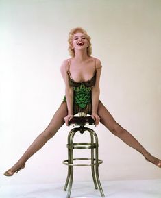 a woman sitting on top of a metal stool