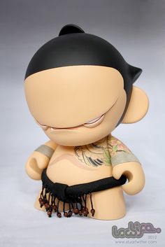 a small doll with tattoos on it's arm and chest sitting next to a white background