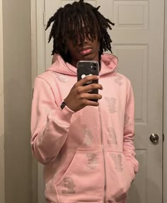 a young man with dreadlocks taking a selfie in front of a door