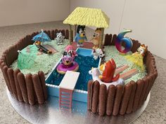 a cake that is decorated to look like a pool with people in it and an umbrella