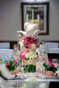 a wedding cake decorated with flowers and pearls on top of a table in a room