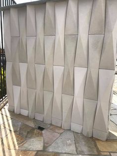 a large white sculpture sitting on top of a stone floor next to a metal fence